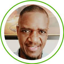 Smiling man with short hair in a circular frame, green border, symbolizing efficient ITSM solutions with SysAid Service Desk. - SysAid