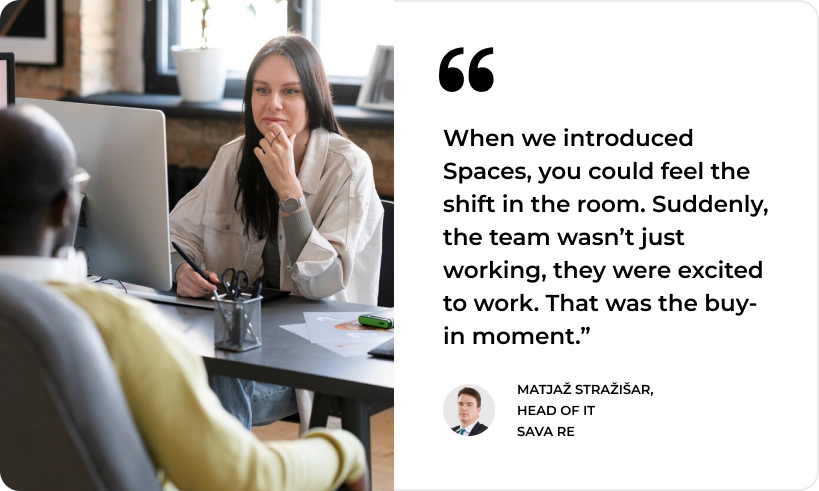 A woman collaborates with a colleague at her desk; SysAid Service Desk empowers IT teams, as praised by Sava Re’s Head of IT. - SysAid
