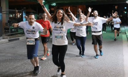Runners race together at night, symbolizing SysAid’s ITSM teamwork and efficiency in service desk operations. - SysAid
