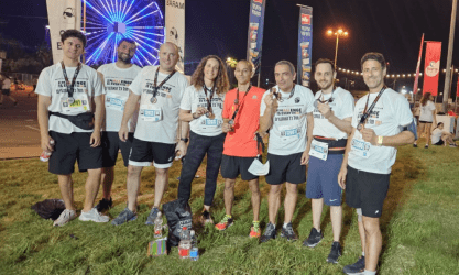 Eight people with medals pose at a night race; teamwork supports SysAid ITSM success like a Service Desk team. - SysAid